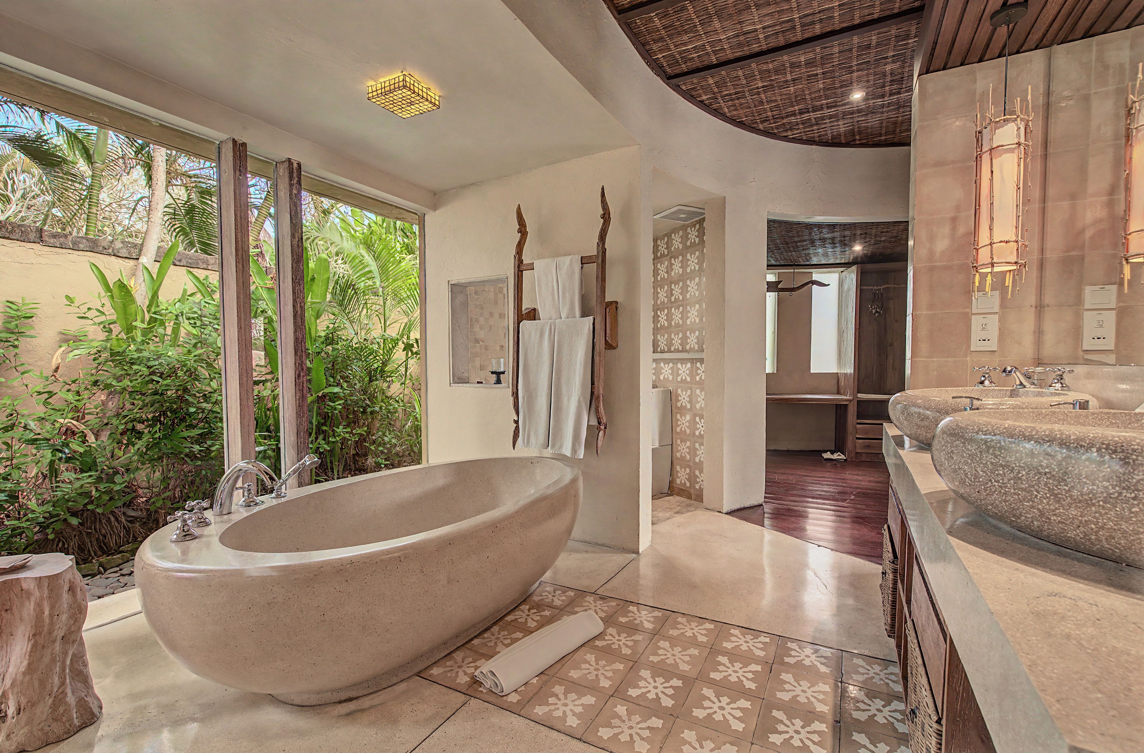 Une salle de bain moderne dotée d’une baignoire sur pieds, d’une douche séparée et d’un meuble-lavabo avec plusieurs vasques.