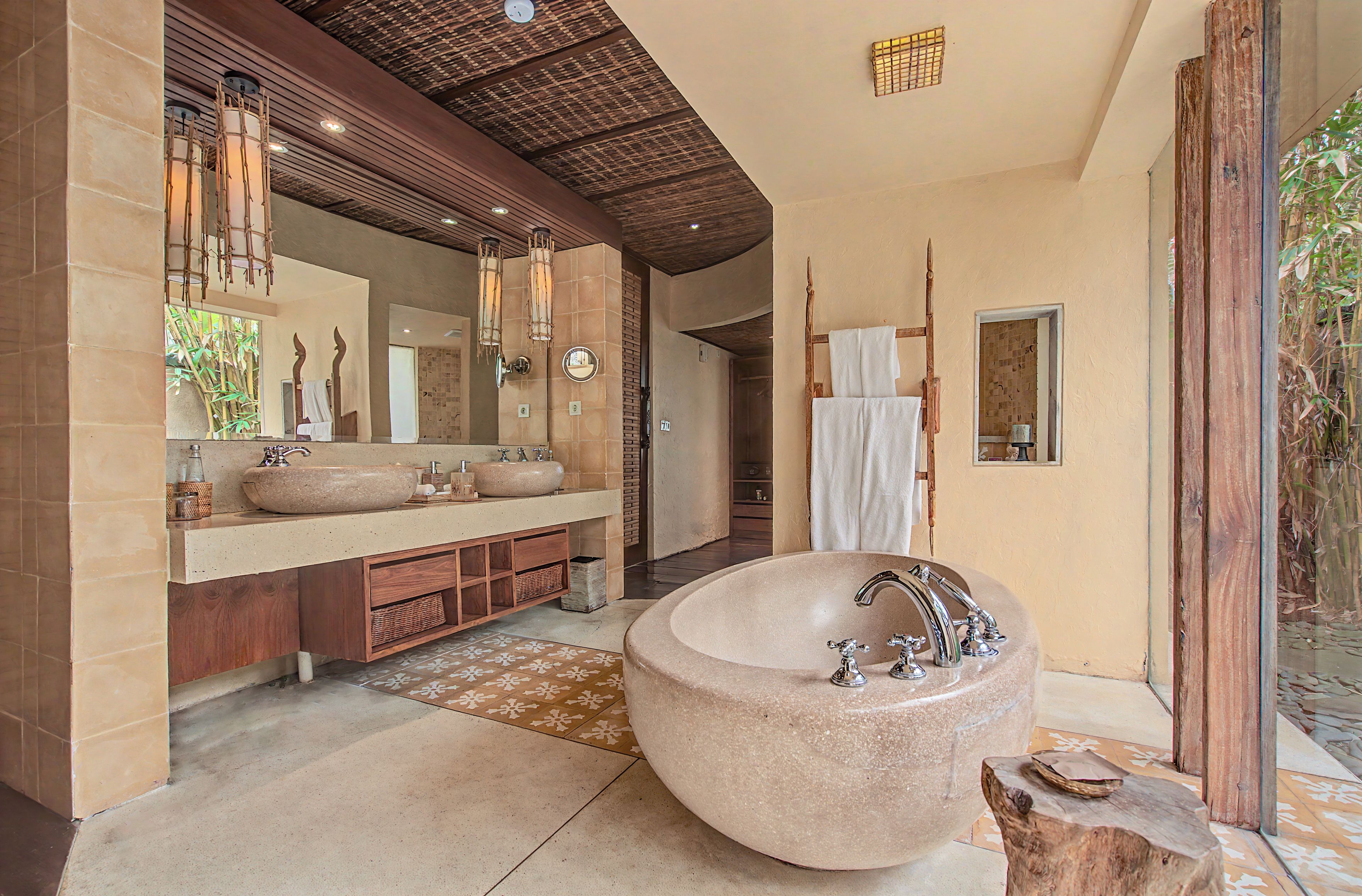 A bathroom with a large freestanding bathtub, a double vanity with two sinks, and a large mirror above the vanity.