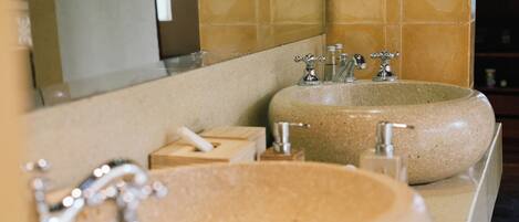 A bathroom with two sinks, a mirror, and a towel dispenser.