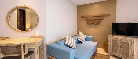 A room with a bed, a desk, a chair, a television, and a wall-mounted shelf.