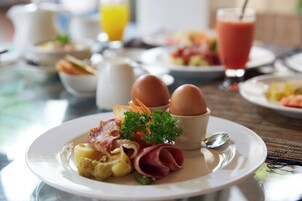 Desayuno con huevos, tocino, jamón y verduras.