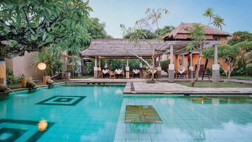 Alberca al aire libre, sombrillas en la alberca y camastros