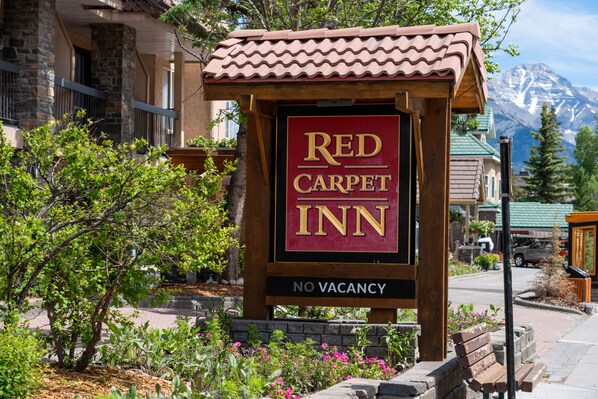 A Red Carpet Inn sign with a mountainous backdrop. - Red Carpet Inn (Banff)