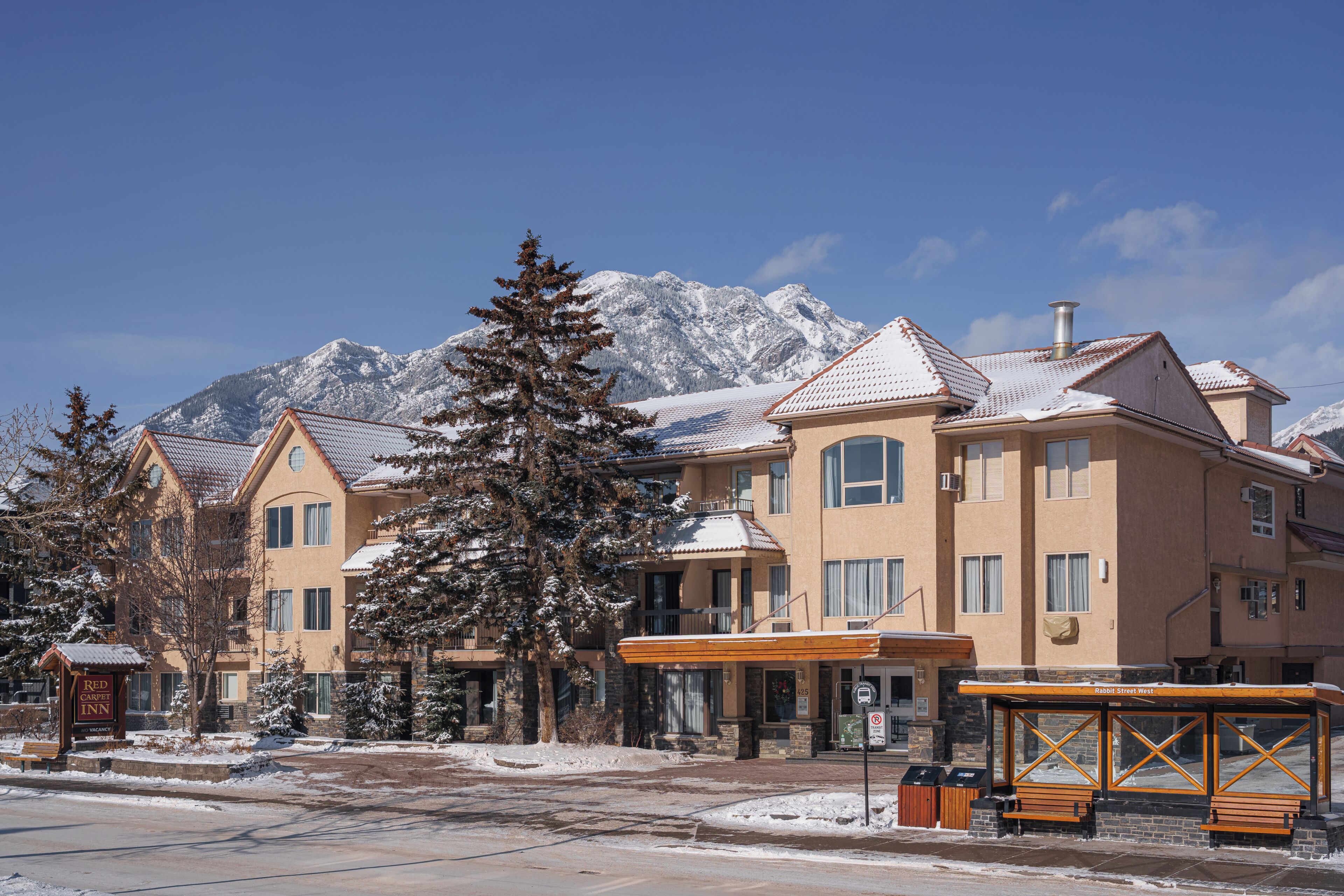 Un hotel con vistas a la montaña, que presenta un estilo arquitectónico tradicional con varios pisos y una entrada destacada.