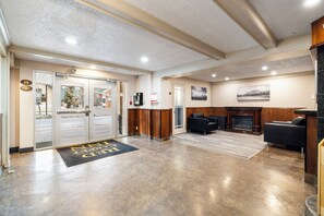 A hotel lobby with a reception desk, seating area, and a fireplace.