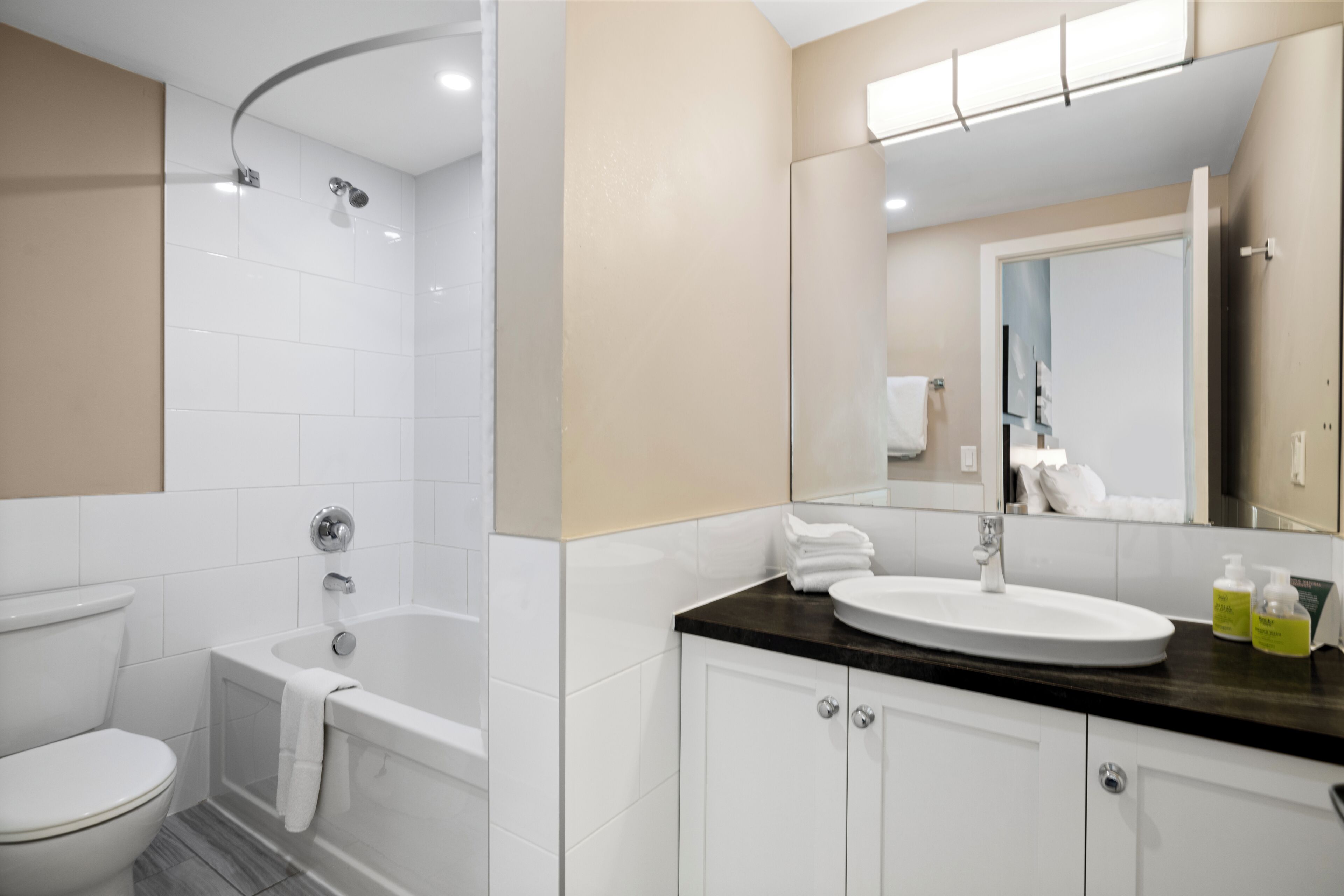 A modern bathroom with a bathtub, toilet, and sink.