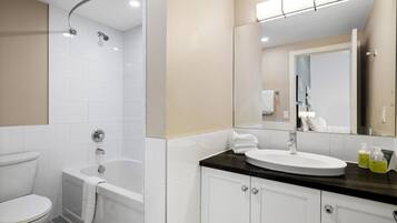 A modern bathroom with a bathtub, toilet, and sink.
