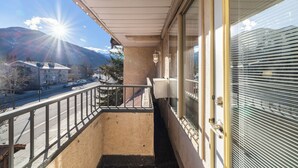 A balcony with a view of a street and mountains.