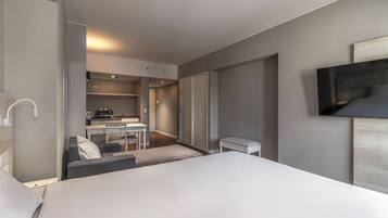 Una habitación de hotel moderna con una cama, un escritorio y un televisor.