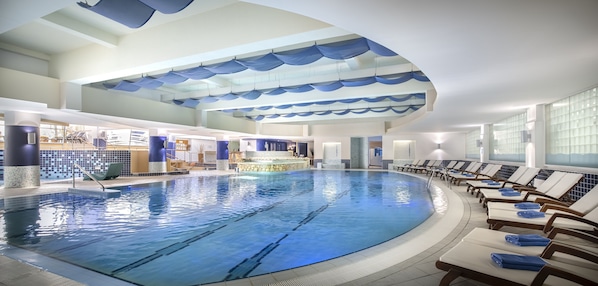 An indoor swimming pool with lounge chairs and a bar area. - Valamar Diamant Hotel (Porec)
