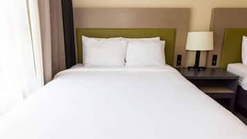 A hotel room with a large bed, two bedside tables, a lamp, and a window with curtains.