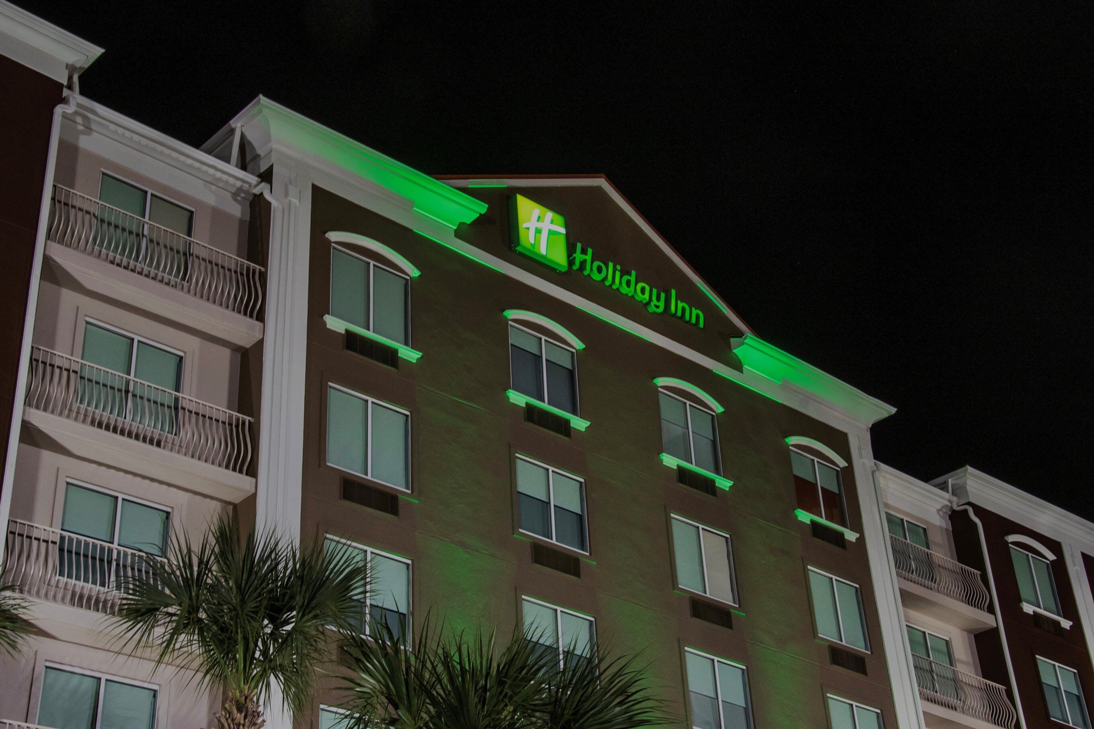 A multi-story building with balconies and a sign indicating it is a Holiday Inn.