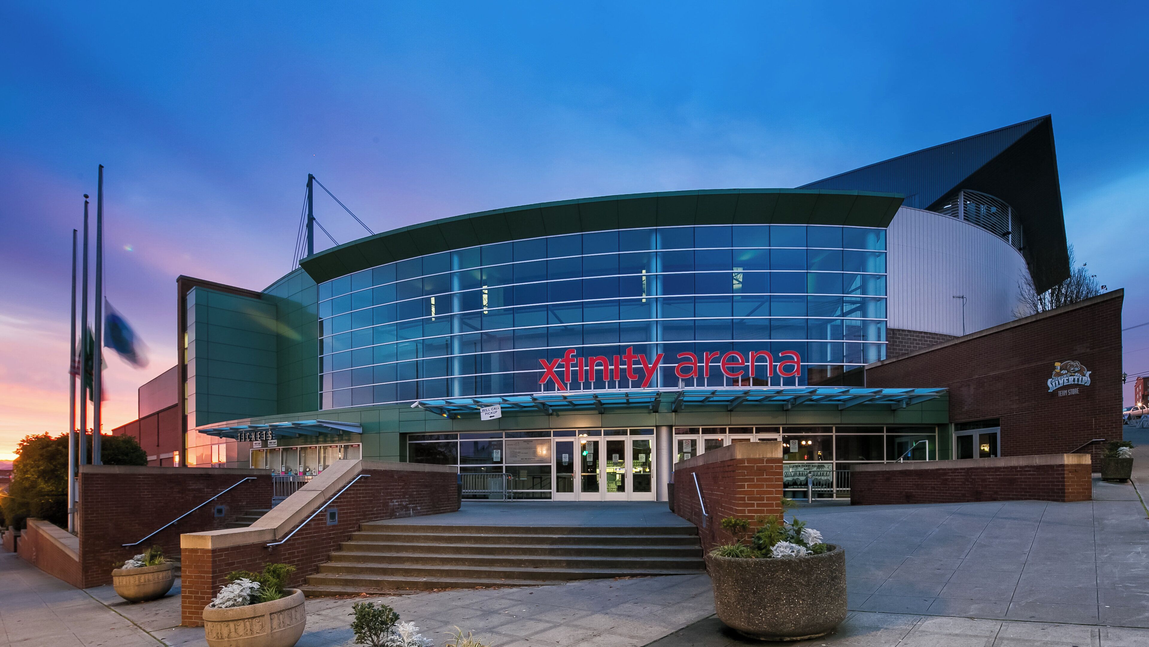 A modern building with a curved glass facade and a prominent 'Xfinity Arena' sign.