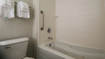 A bathroom with a toilet, a bathtub, and a shower area.