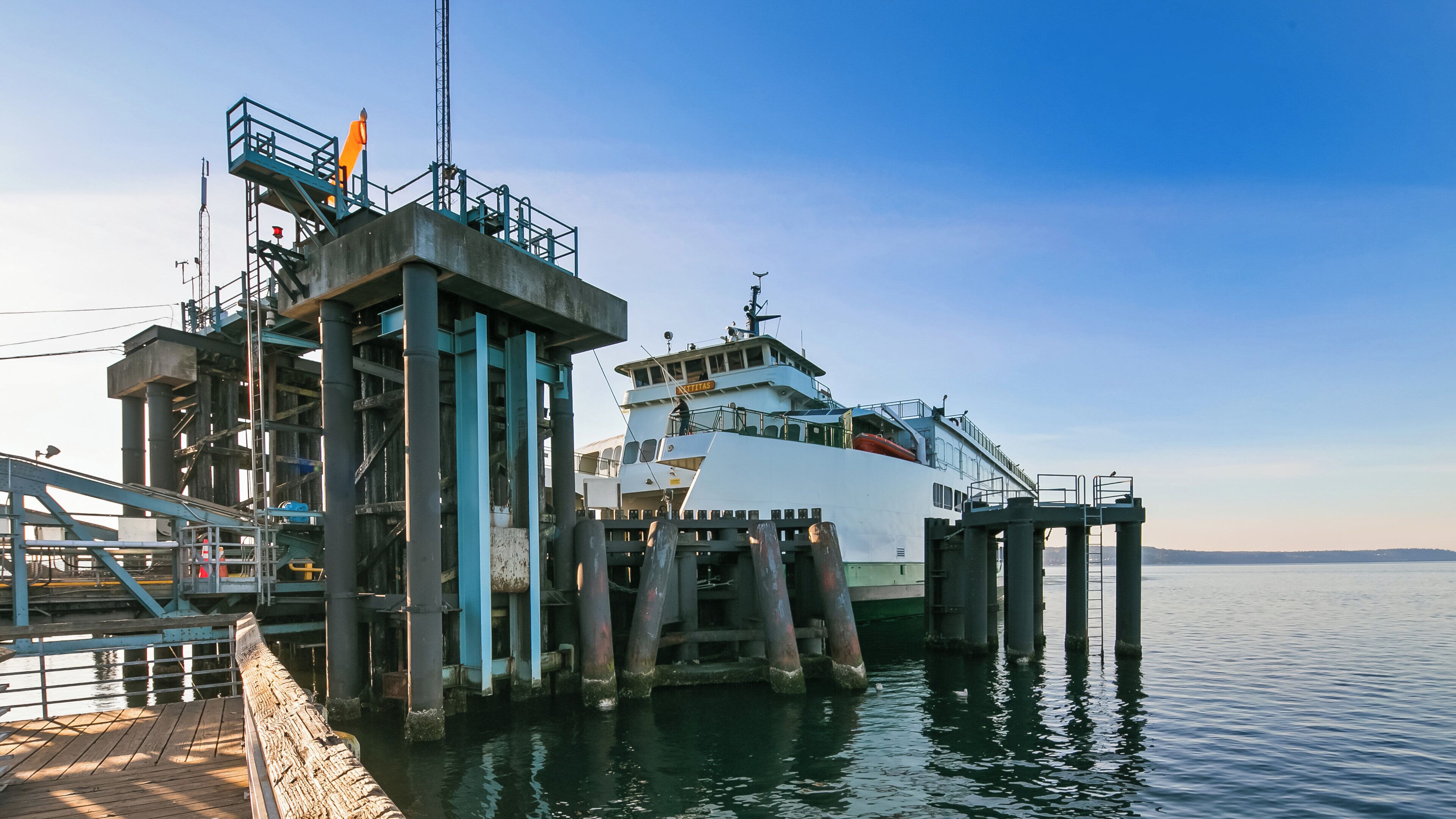 A docked ferry with a metal structure and a walkway leading to it.