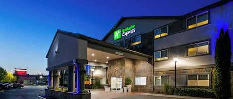 A Holiday Inn Express building with a clear entrance, a parking lot, and a sign indicating clearance.