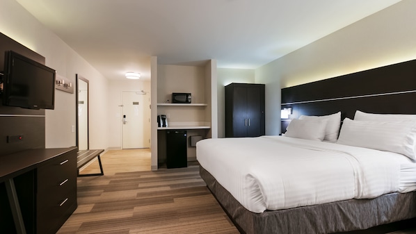 A modern hotel room with a large bed, a desk with a flat-screen TV, a microwave, and a wardrobe. - Holiday Inn Express & Suites Everett by IHG (Everett)