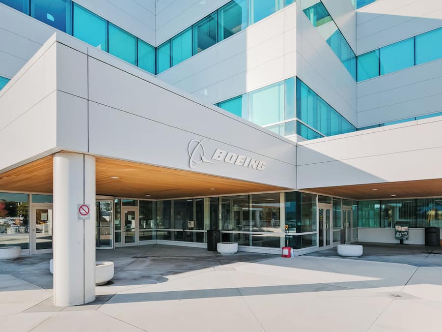 Un edificio moderno con fachada de vidrio y un cartel que dice 'BOEING'.