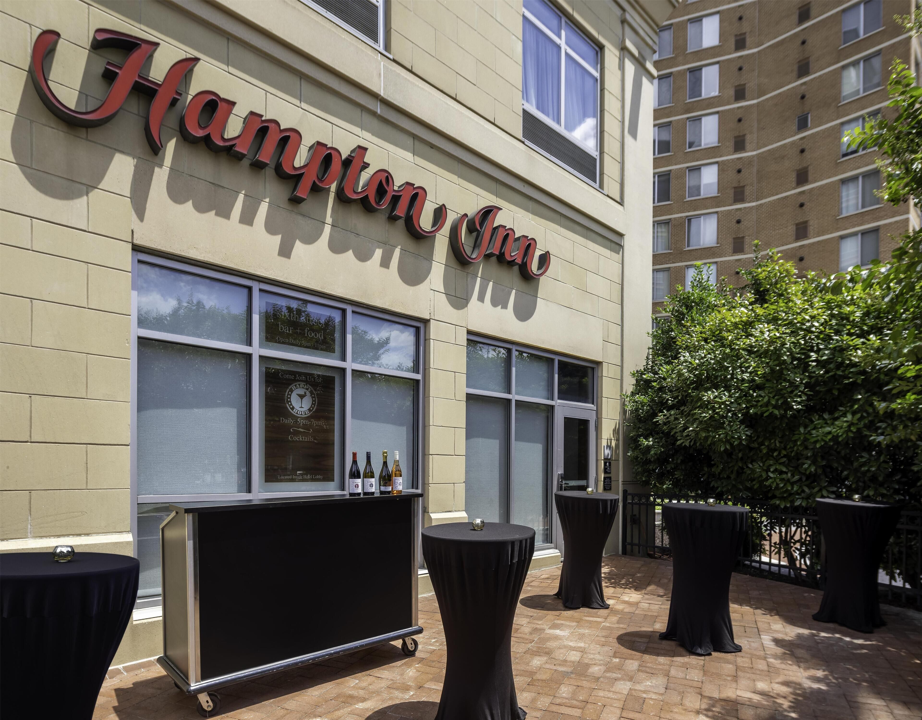A hotel exterior with a sign reading 'Hampton Inn.'