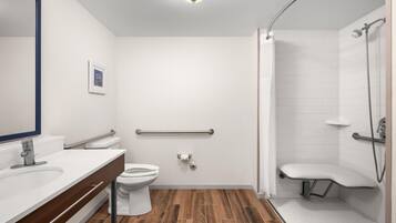 Une salle de bain moderne équipée de toilettes, d’un lavabo et d’un espace douche.