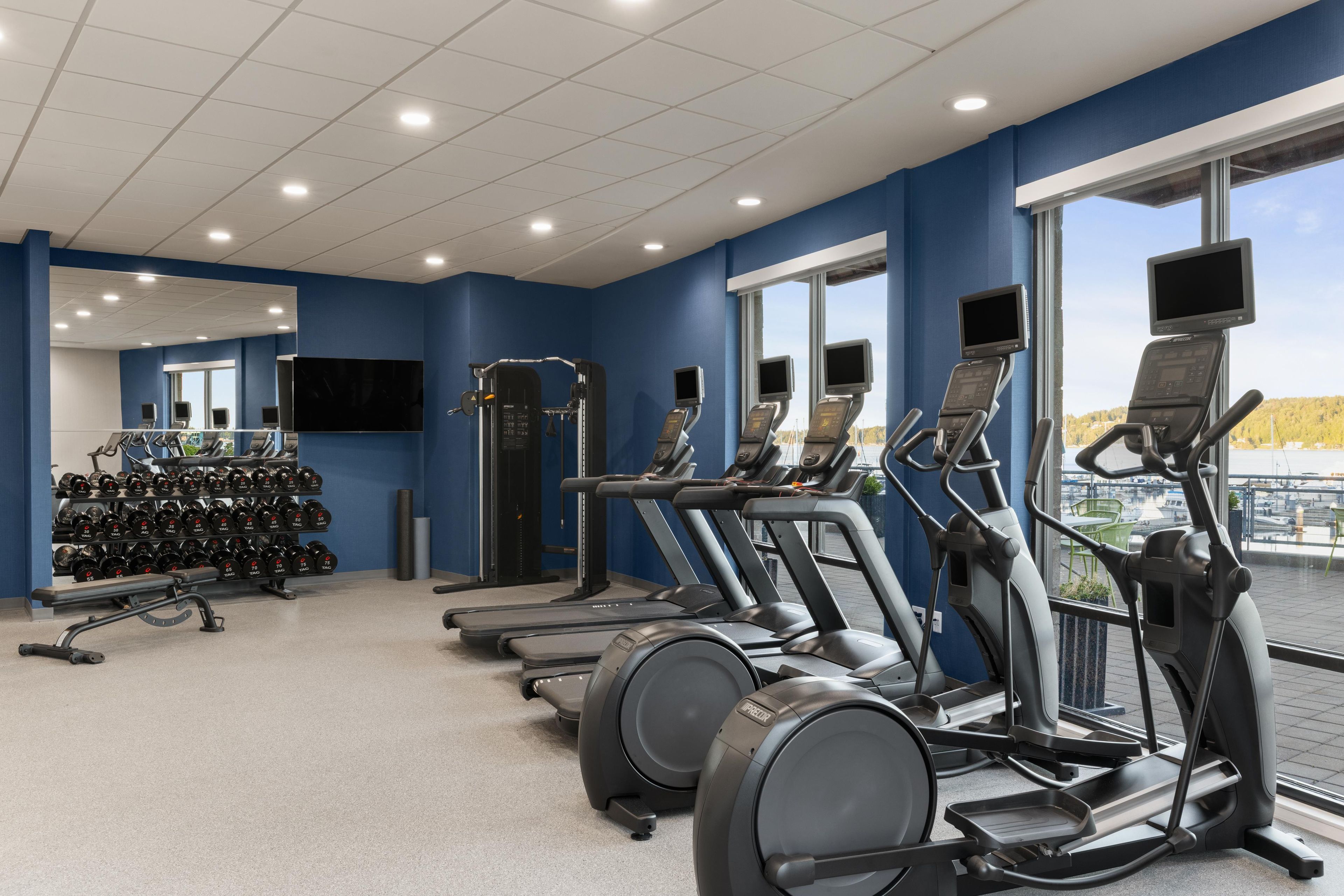 A gym with treadmills, elliptical machines, and weightlifting equipment.
