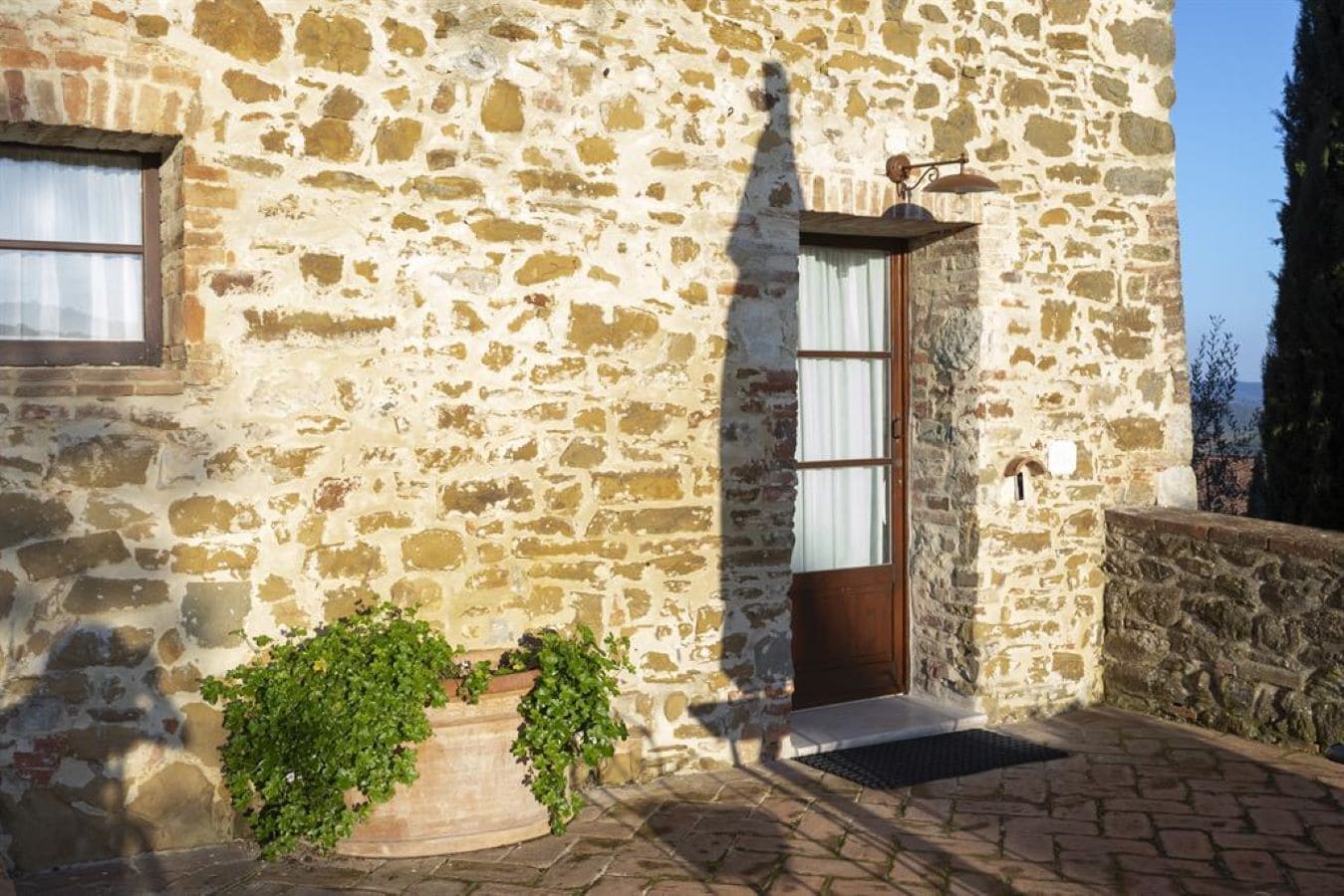 A stone building with a wooden door and a window.