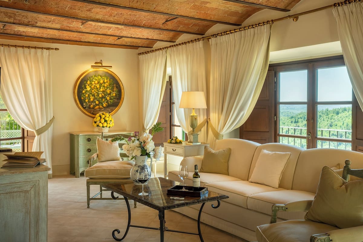 Un salon chaleureux avec un canapé, une table basse et une vue sur la verdure grâce à de grandes fenêtres.