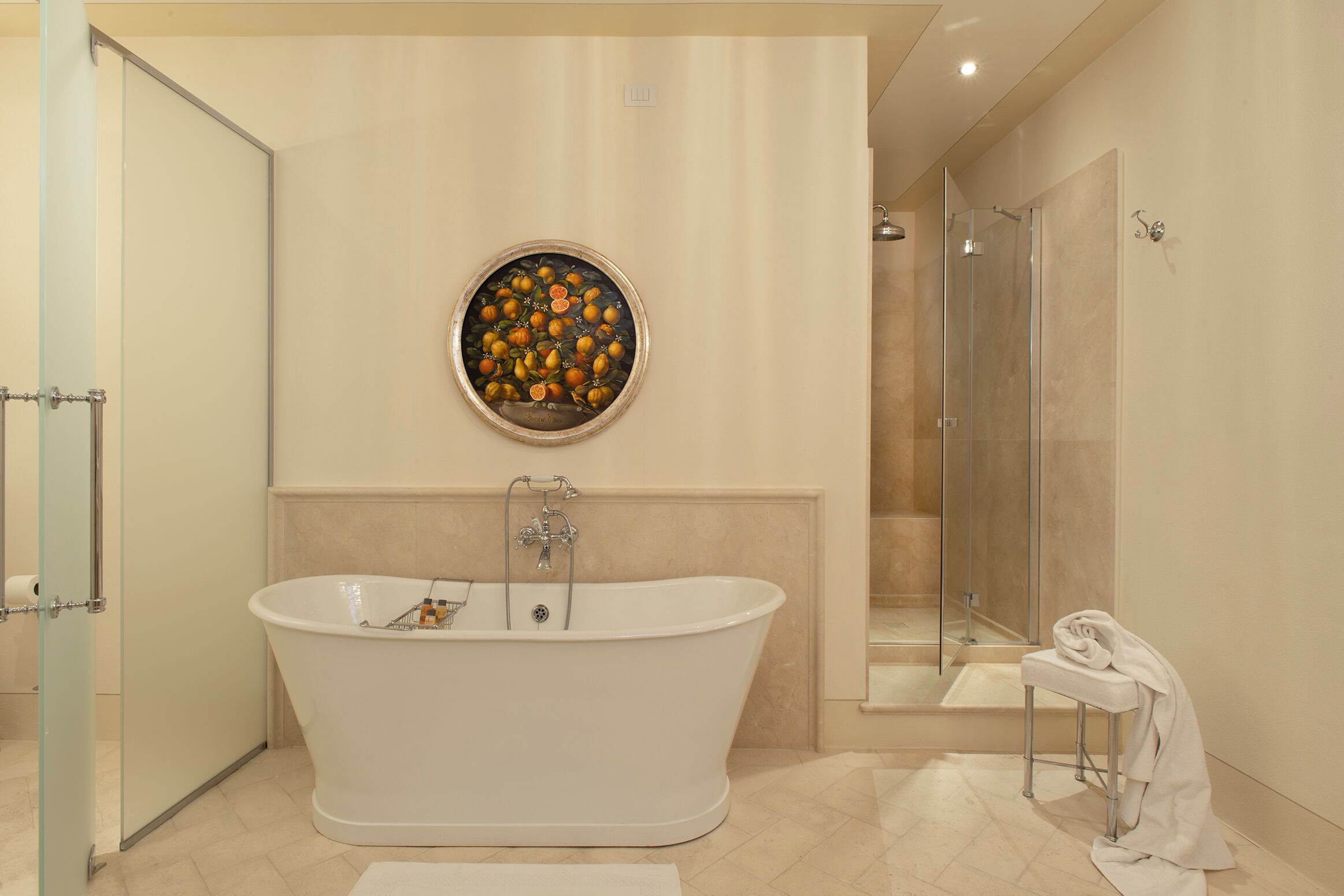 Une salle de bain moderne avec une baignoire sur pieds, une douche en verre et une œuvre d’art fixée au mur.