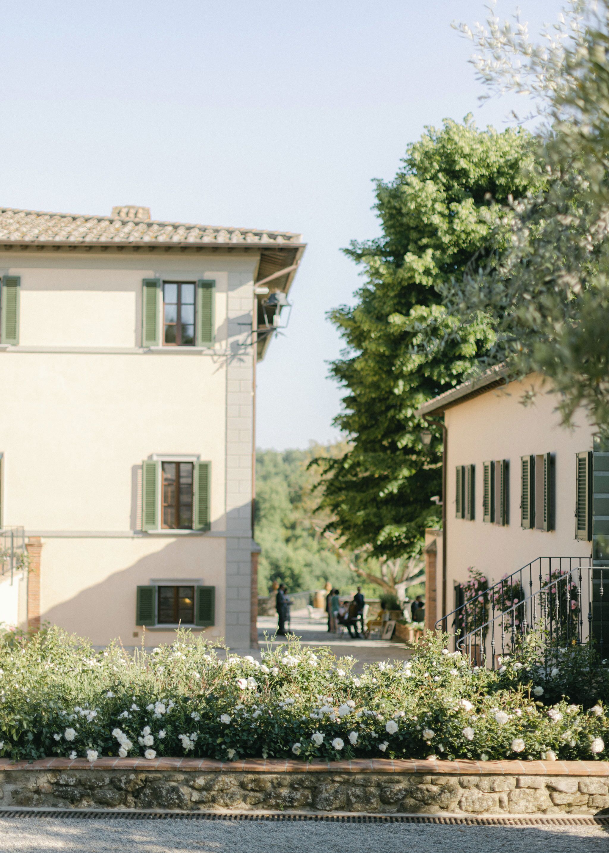 A building with a stone facade, green shutters, and a balcony.