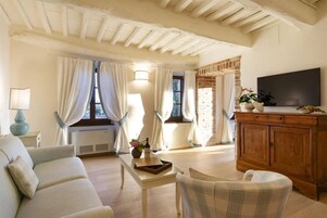 Suite superior, 1 cama de matrimonio grande | Sala de estar | Televisión de pantalla plana de 32 pulgadas con canales por satélite