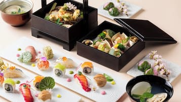 Verschiedene Sushi-Gerichte und eine Schüssel Suppe auf einem Tisch.