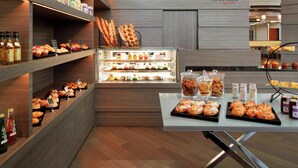 Mostrador de pastelería con diversas opciones de panadería y productos horneados, como pan y galletas, en un ambiente moderno.