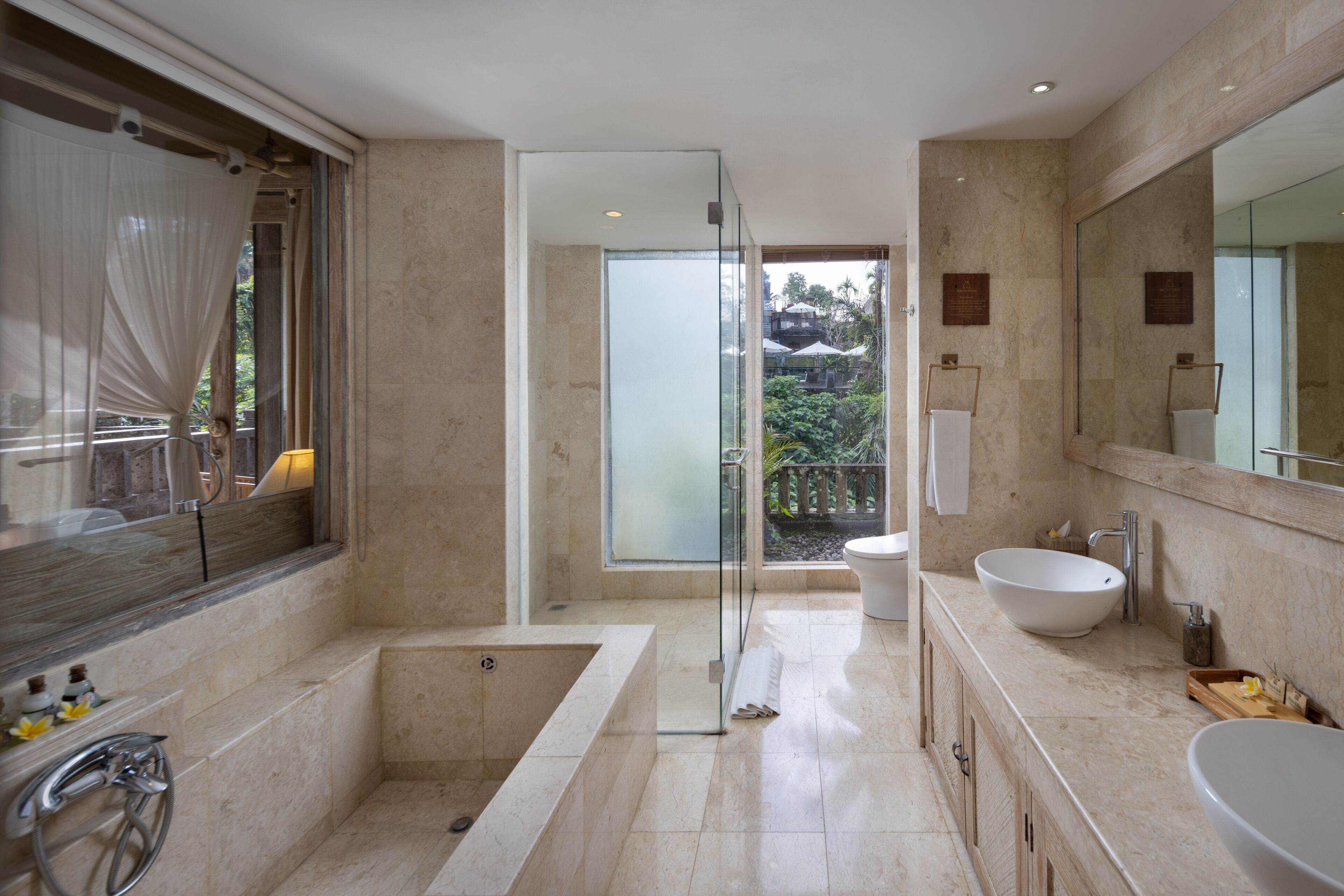 A modern bathroom with a bathtub, two sinks, and a large mirror.