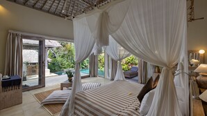 Un dormitorio con cama con dosel, vista a la piscina y un comedor.