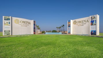 Een groot bord voor DOMINA Coral Bay Resort, met een zwembad in het midden.