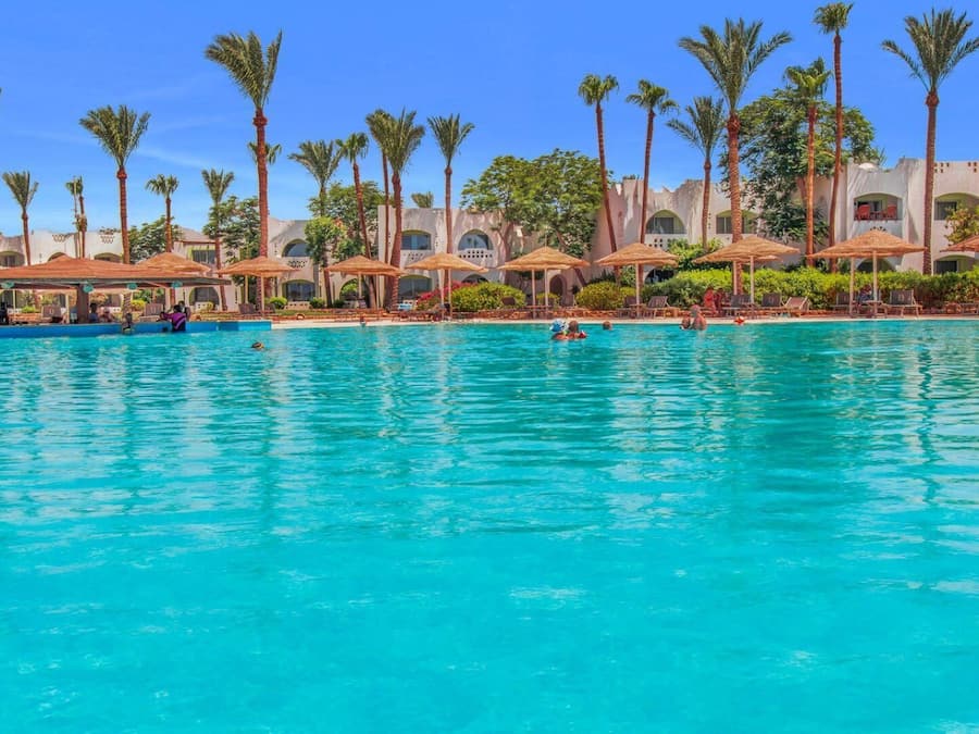 Een buitenzwembad, parasols voor strand/zwembad