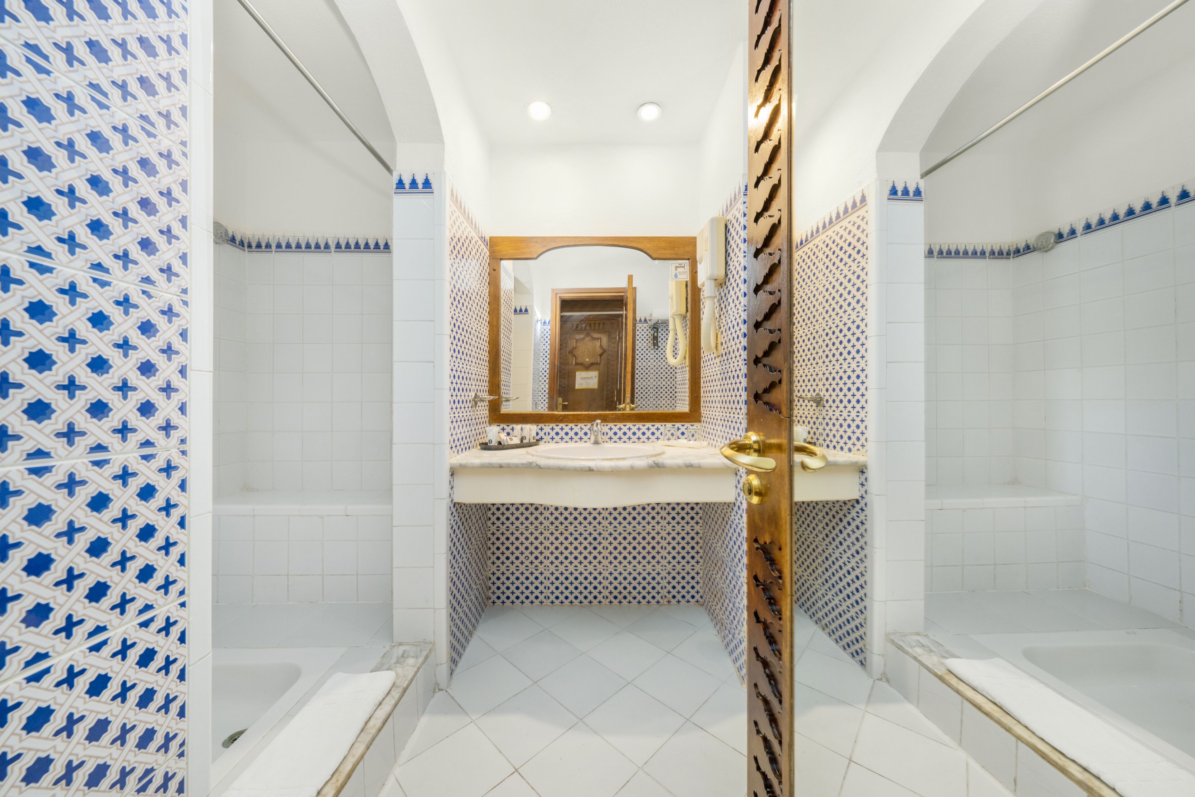 Un baño con una bañera, lavabo y espejo.