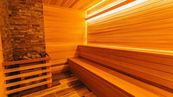 Una sauna con bancos de madera y una pared de piedra.