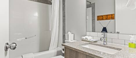 A modern bathroom with a shower, toilet, and sink.