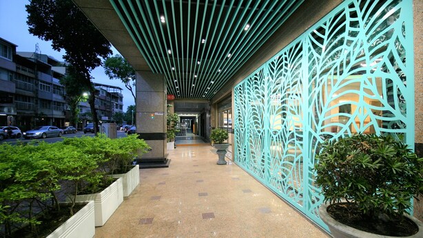 A corridor with a decorative metal fence, potted plants, and a tiled floor. - Kaohsiung Ahotel (Kaohsiung)