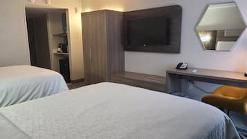 Habitación de hotel con dos camas, un escritorio, una silla, un televisor y un armario.