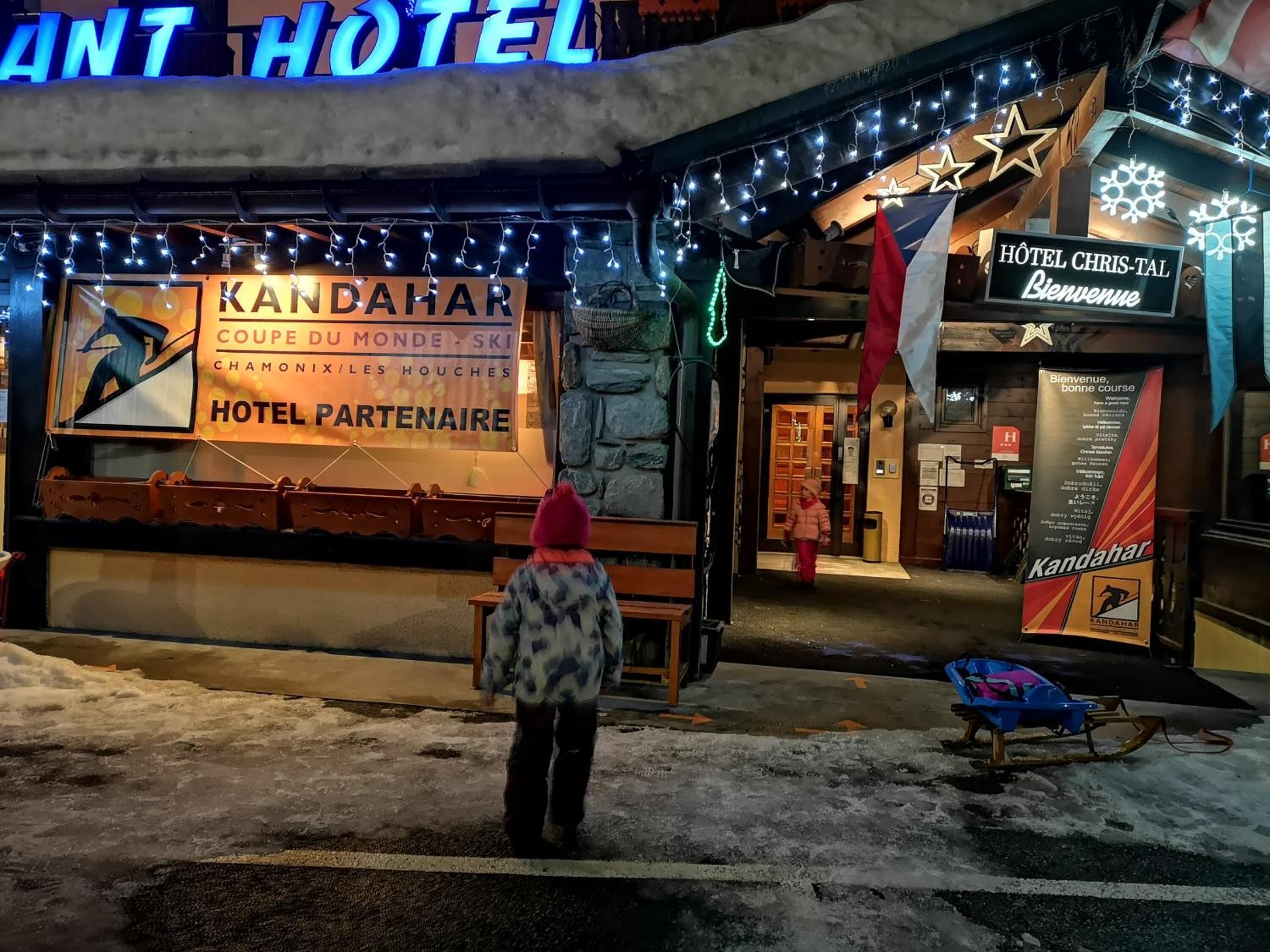 L’entrée d’un hôtel, avec une enseigne indiquant « KANDAHAR HOTEL PARTENAIRE » et « HÔTEL CHRIS-TAL ».