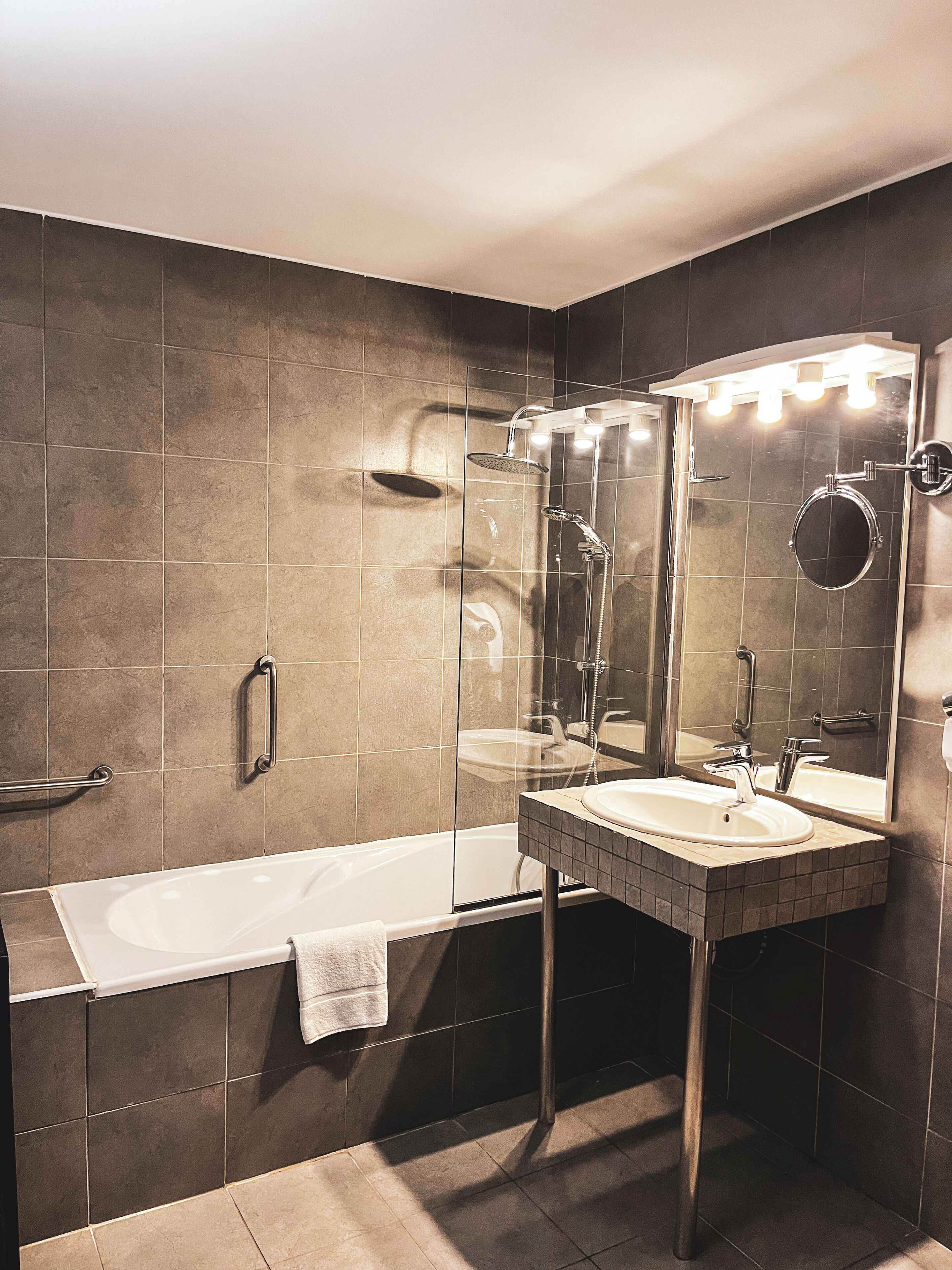 Un baño moderno con bañera, ducha y tocador con espejo.