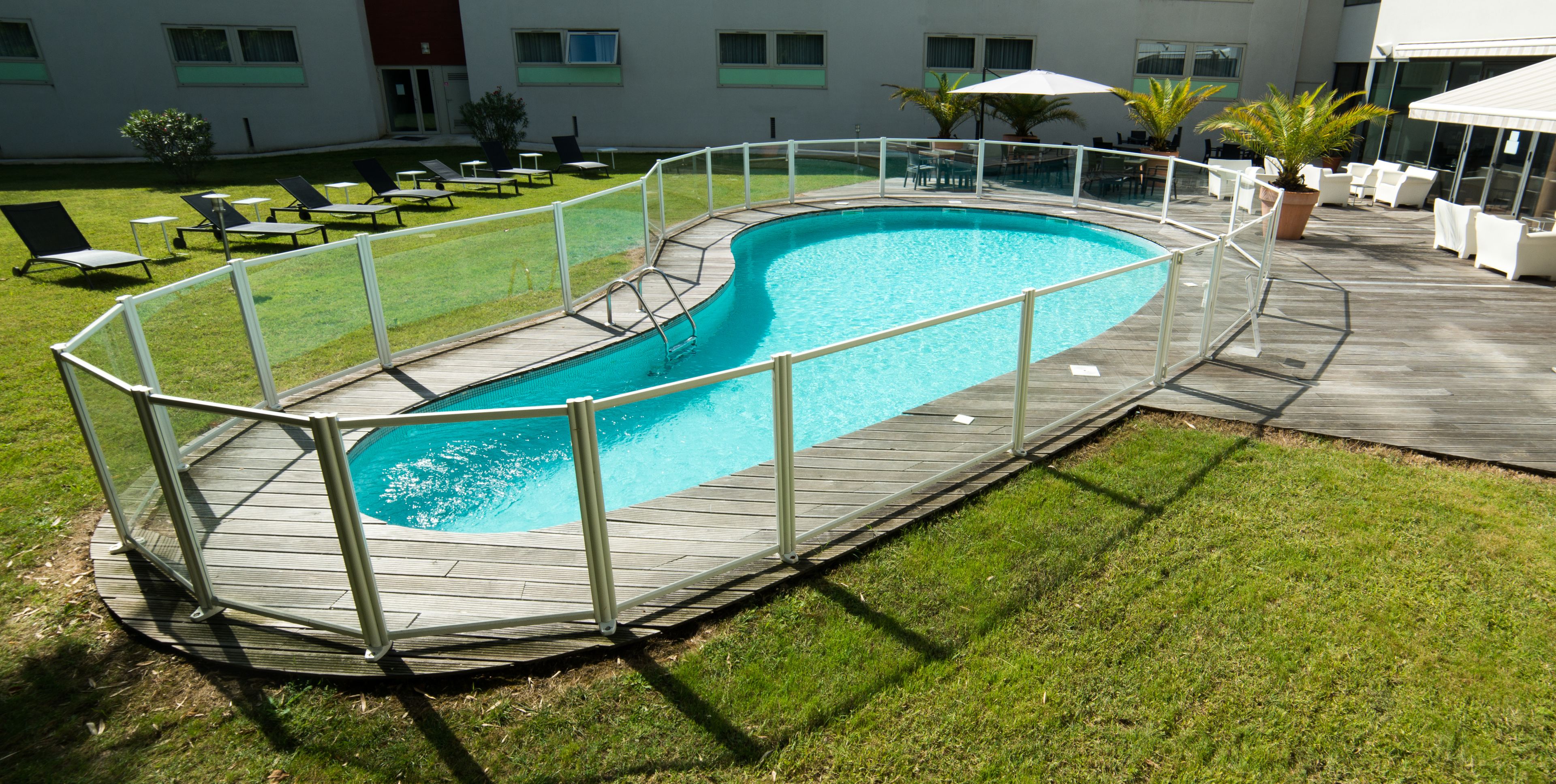 Una piscina al aire libre, sillones reclinables de piscina