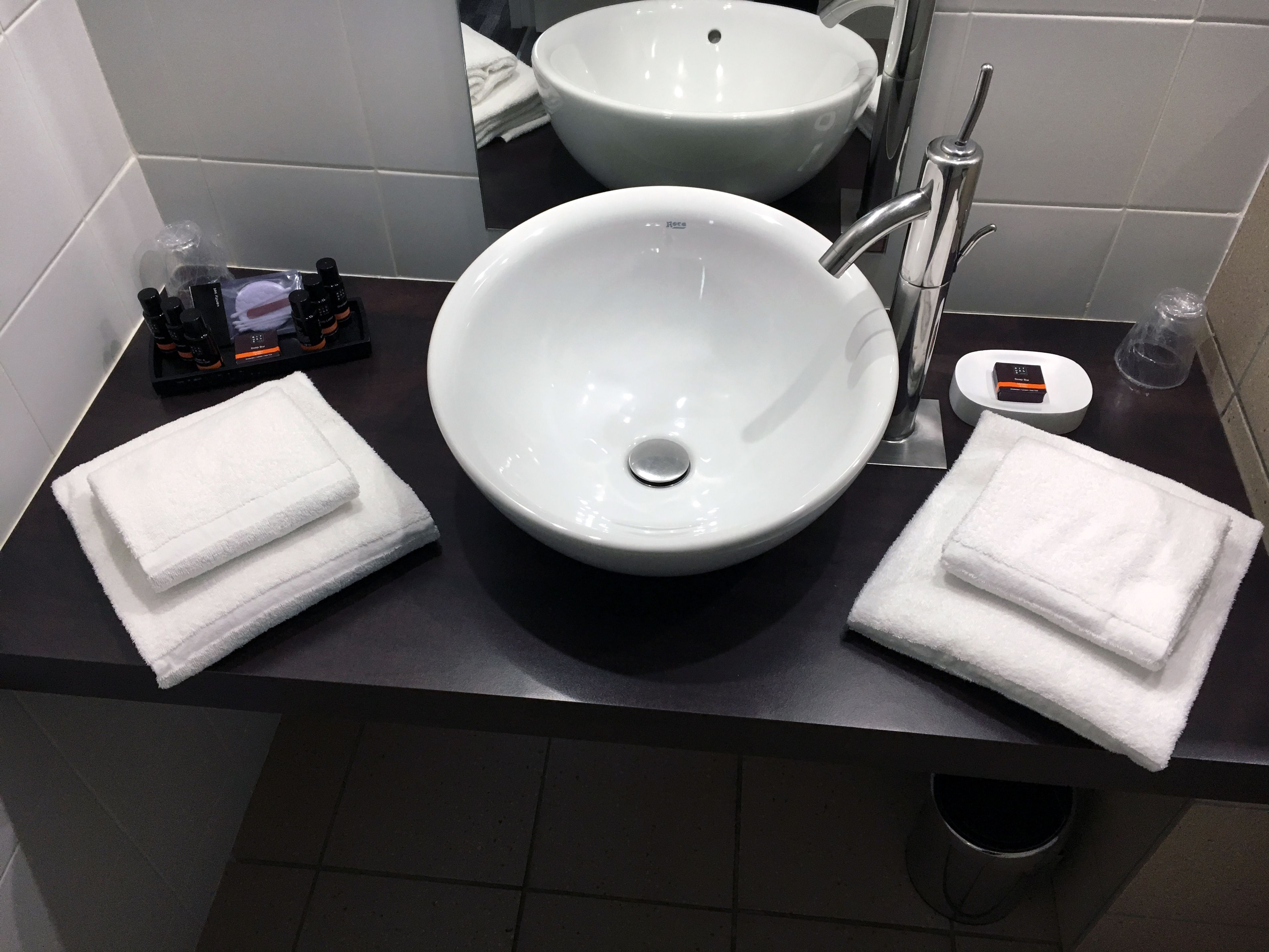 A bathroom with two white sinks, a mirror, and a black countertop.