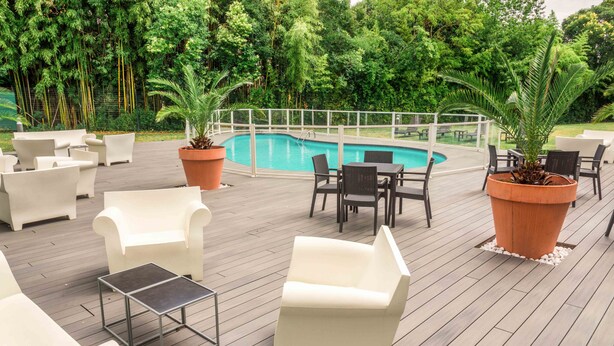 A poolside area with outdoor seating, a pool, and surrounding greenery. - Mercure Agen Centre (Agen)