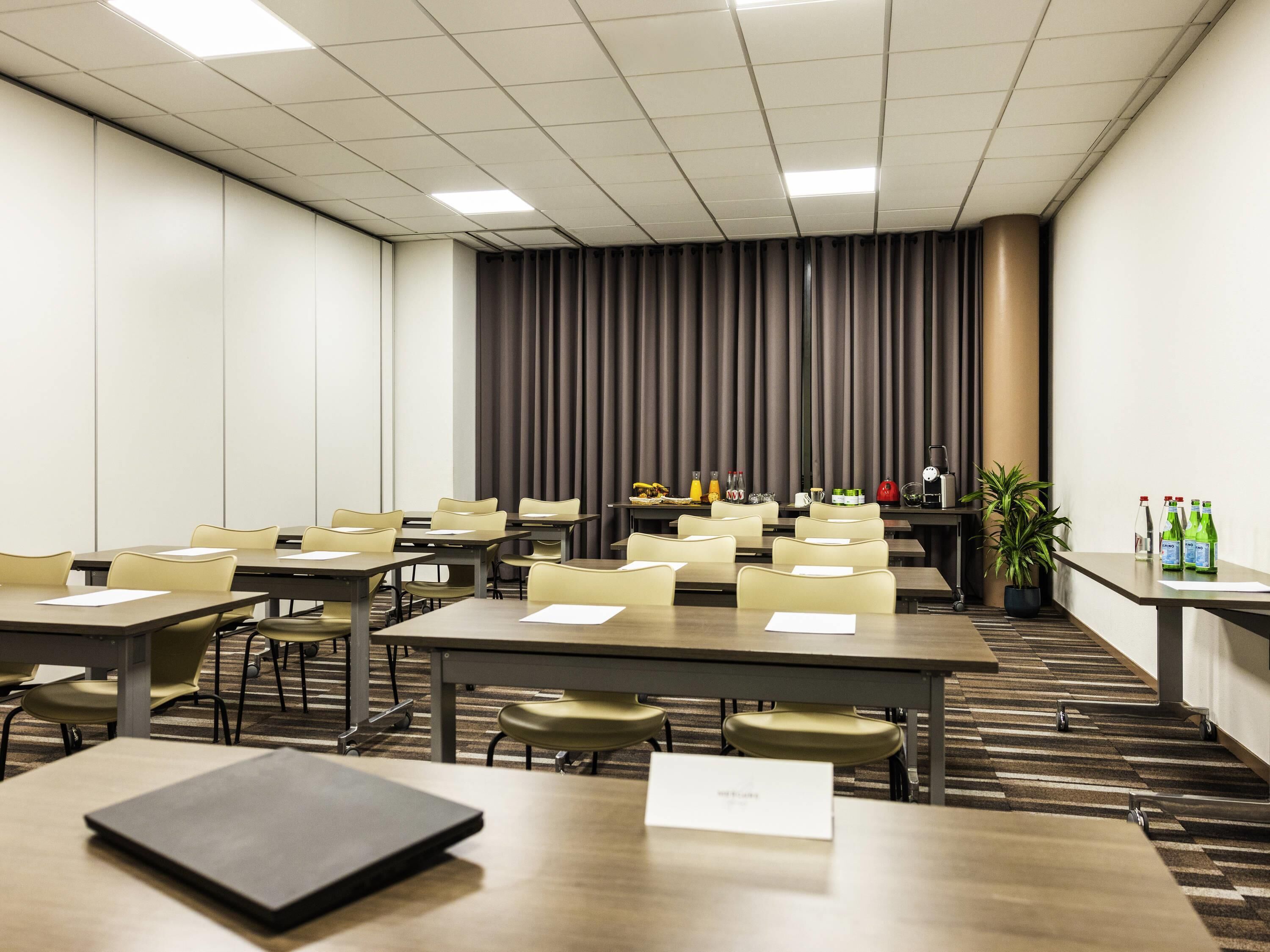 A conference room with tables, chairs, a podium, and a curtain backdrop.