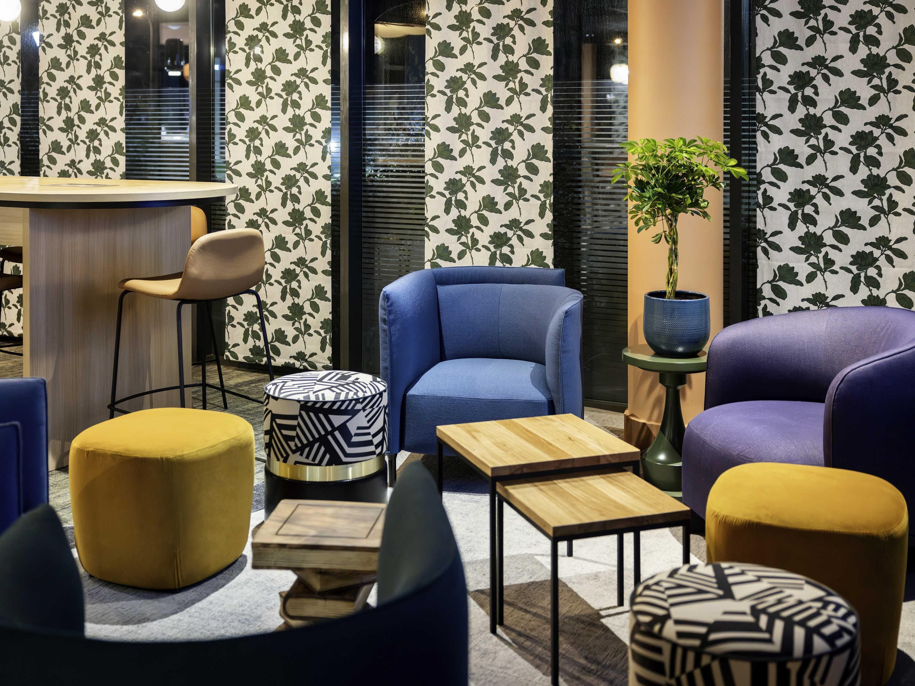 A modern lounge area with a bar, seating, and a potted plant.