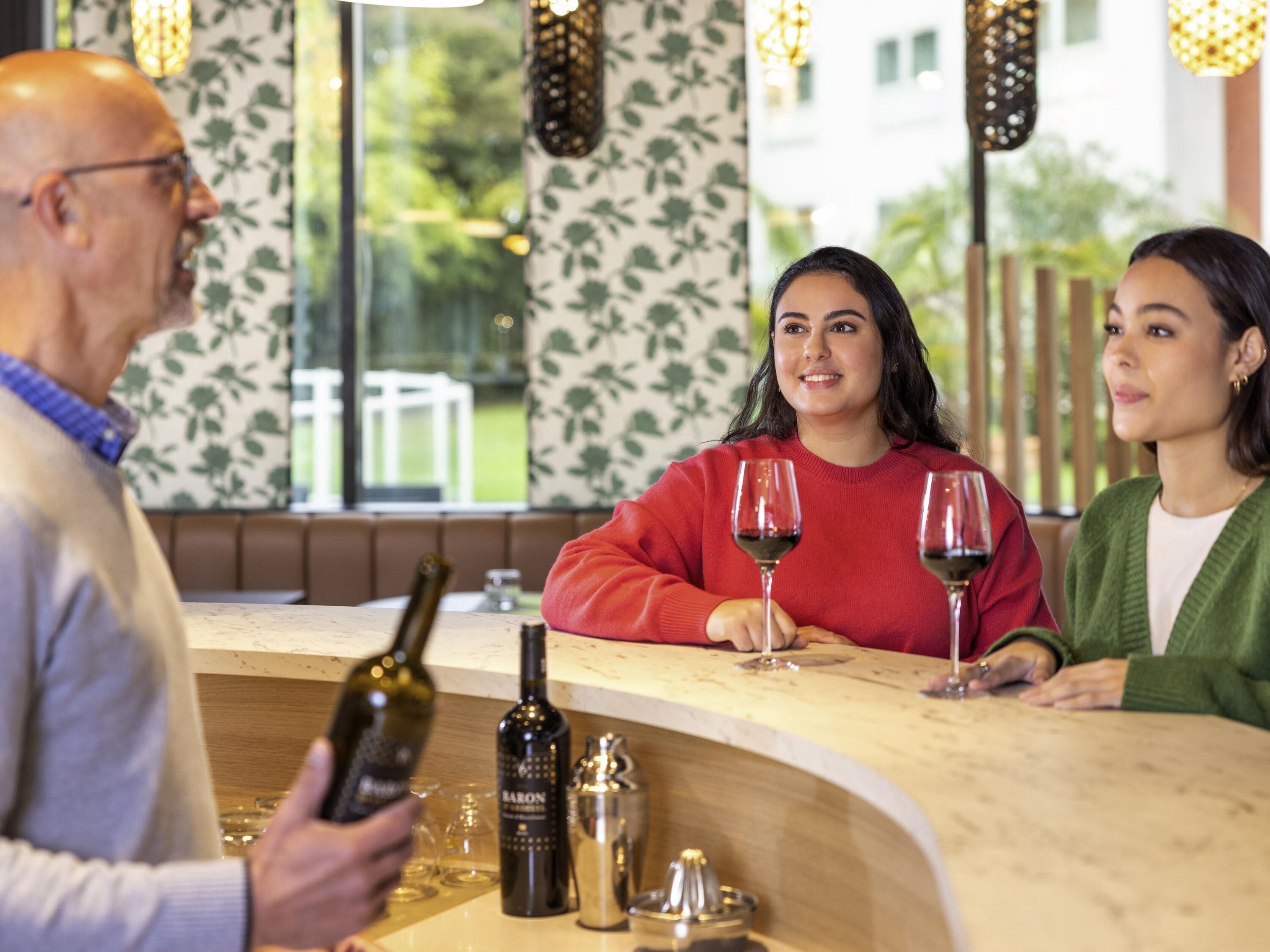 Uma área de bar com balcão, copos de vinho e garrafas.