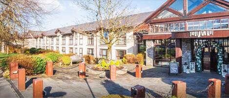A hotel entrance with a traditional building and a modern glass extension.